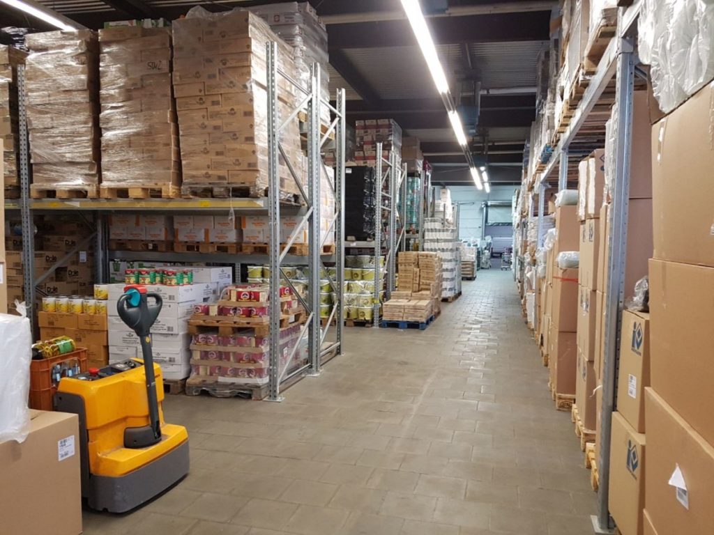 Regale mit Sortiment im Lager von Olympia Großhandel